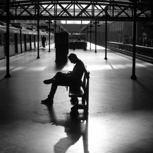 Illustration représentant un individu assis sur un banc dans une gare